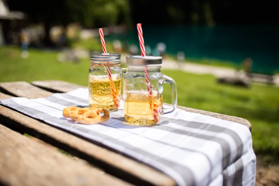 Dos vasos de limonada fría sobre una mesa de madera en un jardín soleado